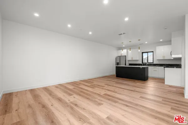 a view of kitchen with kitchen island wooden floor and center island