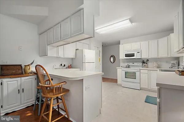 a kitchen with white cabinets stainless steel appliances and sink