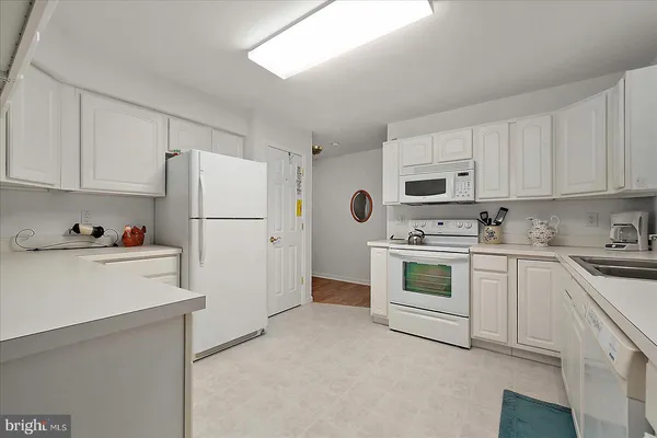 a kitchen with cabinets stainless steel appliances and a refrigerator