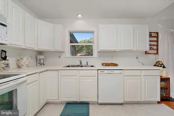 a kitchen with white cabinets and white appliances