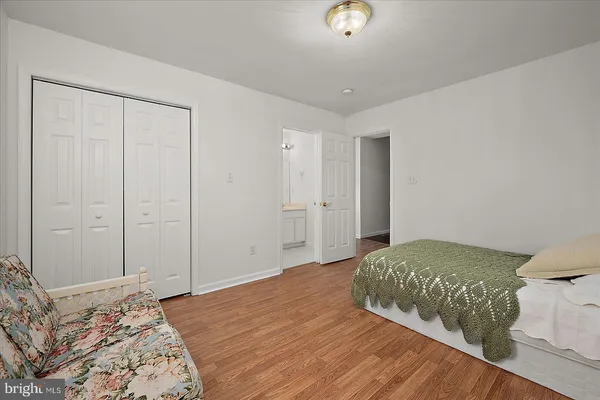 a bedroom with a bed and a wooden floor