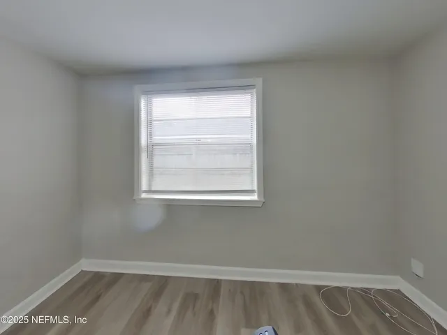 a view of a room with wooden floor and a window