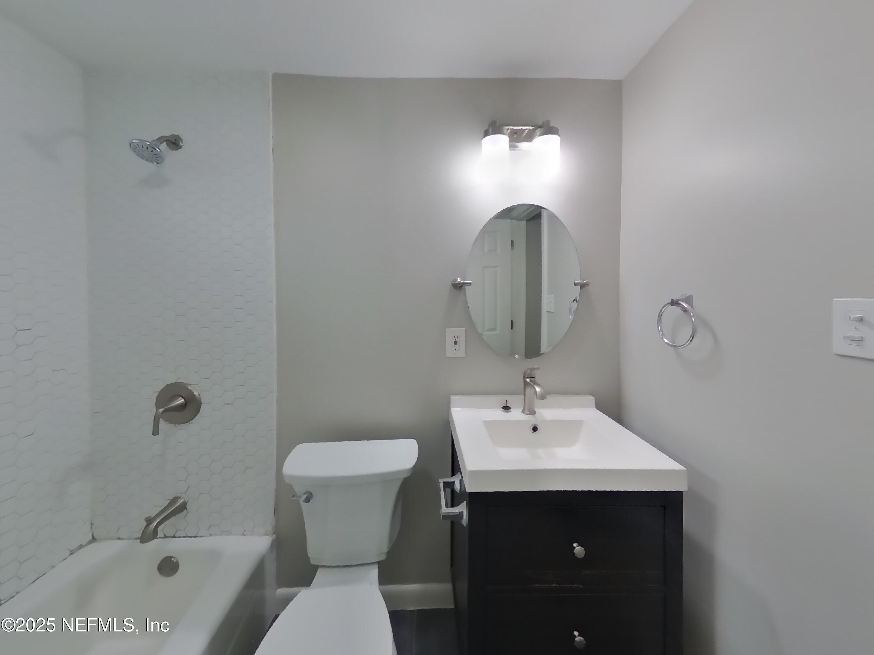 5807 Ricker Road Jacksonville, FL 32244 - Photo 9 of 13 a bathroom with a sink toilet and a mirror