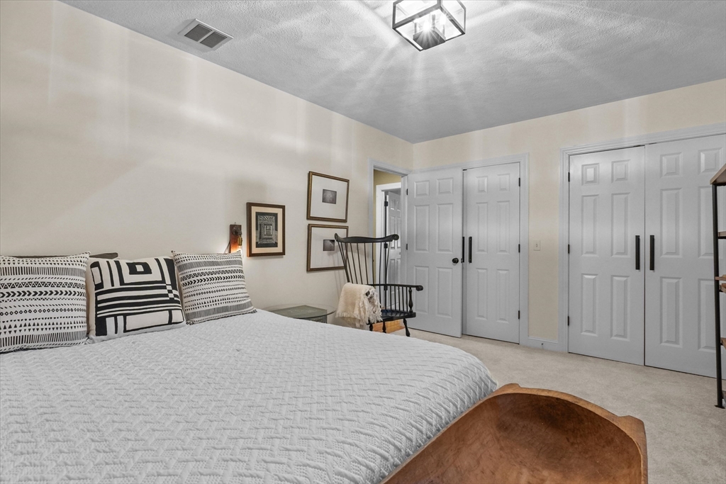 20 Barnside Road Boxford, MA 01921 - Photo 25 of 42 a bedroom with a large bed and a chandelier