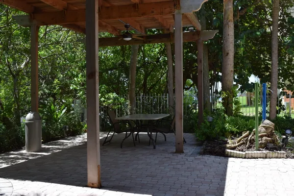 a view of a porch with chairs and potted plants