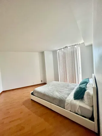 a bedroom with a bed and a window