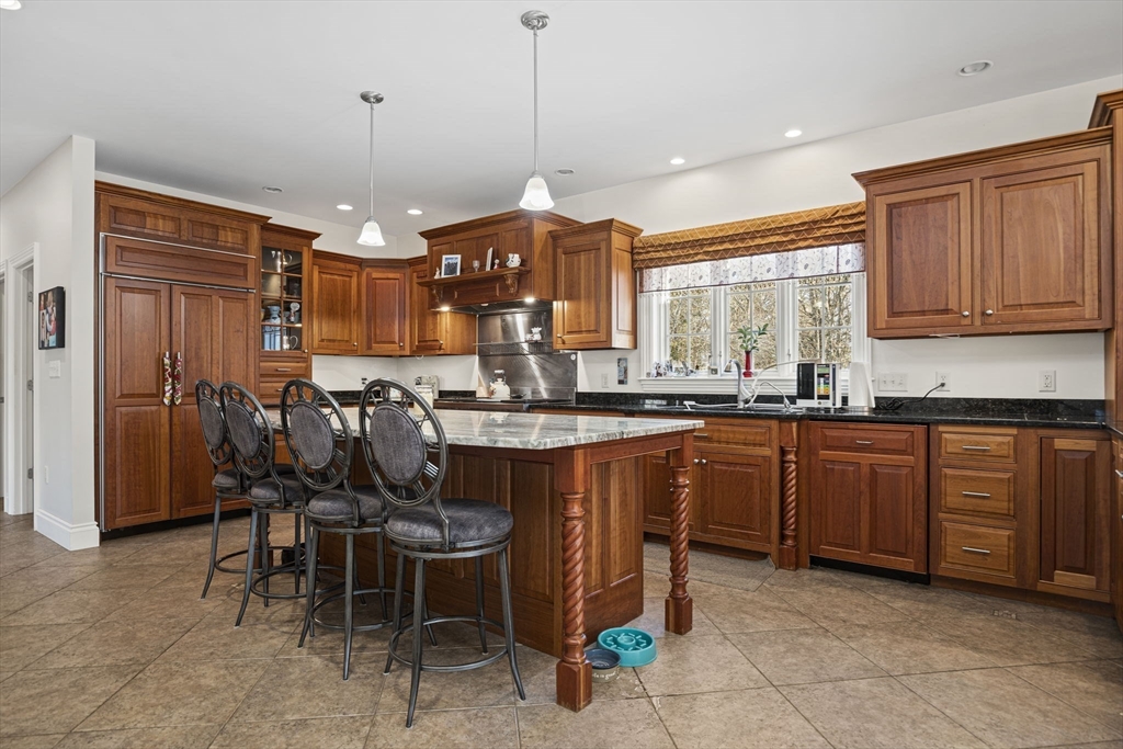 53 Linden Road Hampton Falls, NH 03844 - Photo 6 of 42 a kitchen with stainless steel appliances granite countertop wooden cabinets a dining table and chairs