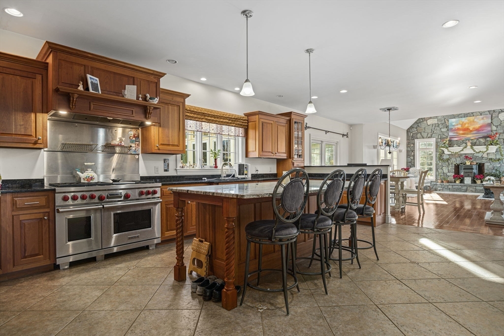53 Linden Road Hampton Falls, NH 03844 - Photo 7 of 42 a kitchen with stainless steel appliances granite countertop a stove top oven a sink dishwasher and a dining table with wooden floor