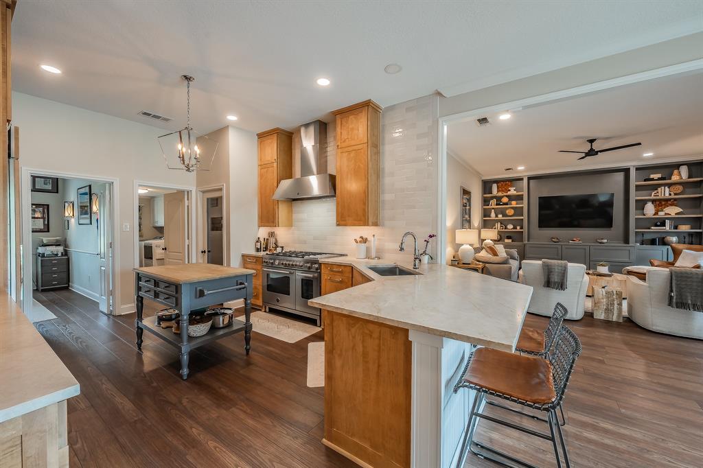 115 Pheasant Run Road Argyle, TX 76226 - Photo 8 of 40 a open kitchen with stainless steel appliances granite countertop a stove a refrigerator a kitchen island a dining table and chairs with wooden floor