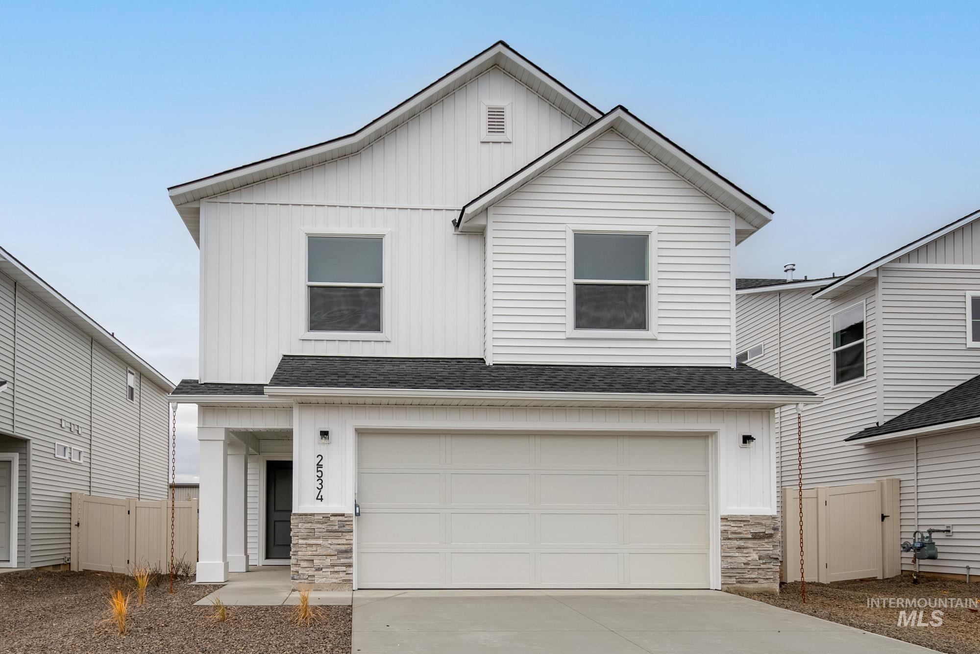 2534 West Fallon Loop Nampa, ID 83651 - Photo 1 of 28 View of front of property with stone siding, roof with shingles, board and batten siding, concrete driveway, and a garage