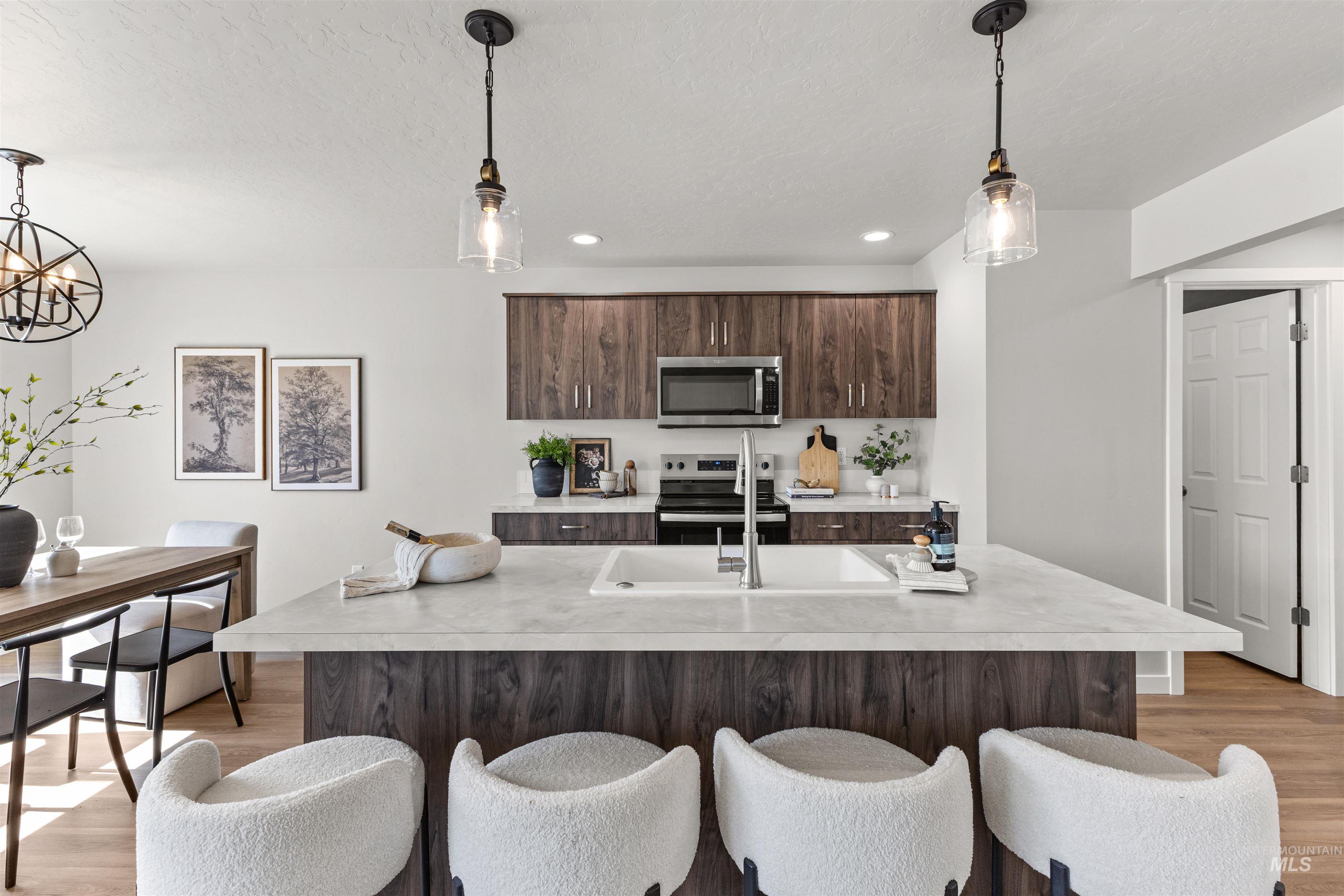 2534 West Fallon Loop Nampa, ID 83651 - Photo 12 of 28 Kitchen featuring pendant lighting, stainless steel appliances, light countertops, a breakfast bar area, and light wood-style flooring