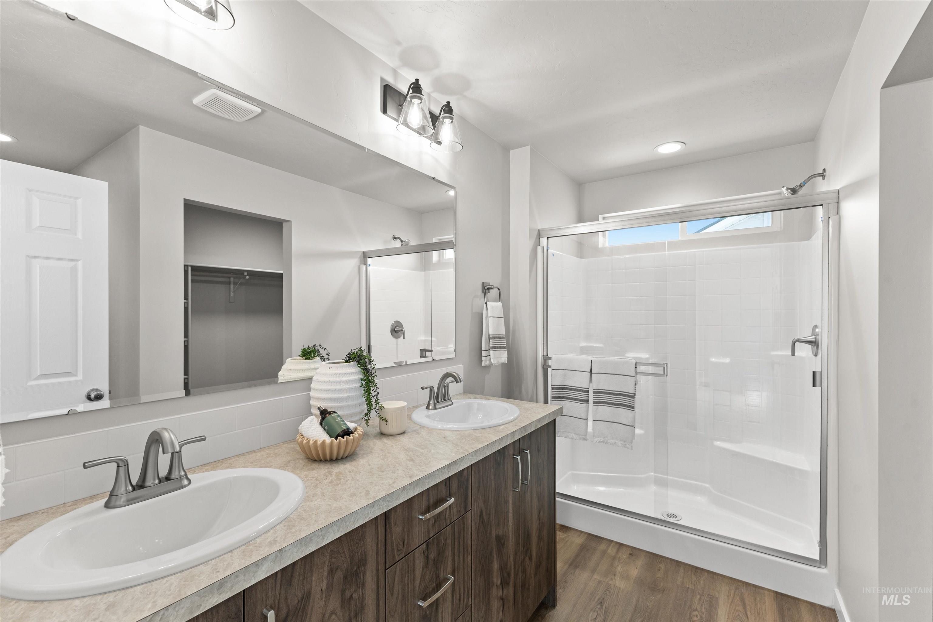 2534 West Fallon Loop Nampa, ID 83651 - Photo 27 of 28 Full bath with double vanity, a shower stall, dark wood finished floors, a walk in closet, and recessed lighting