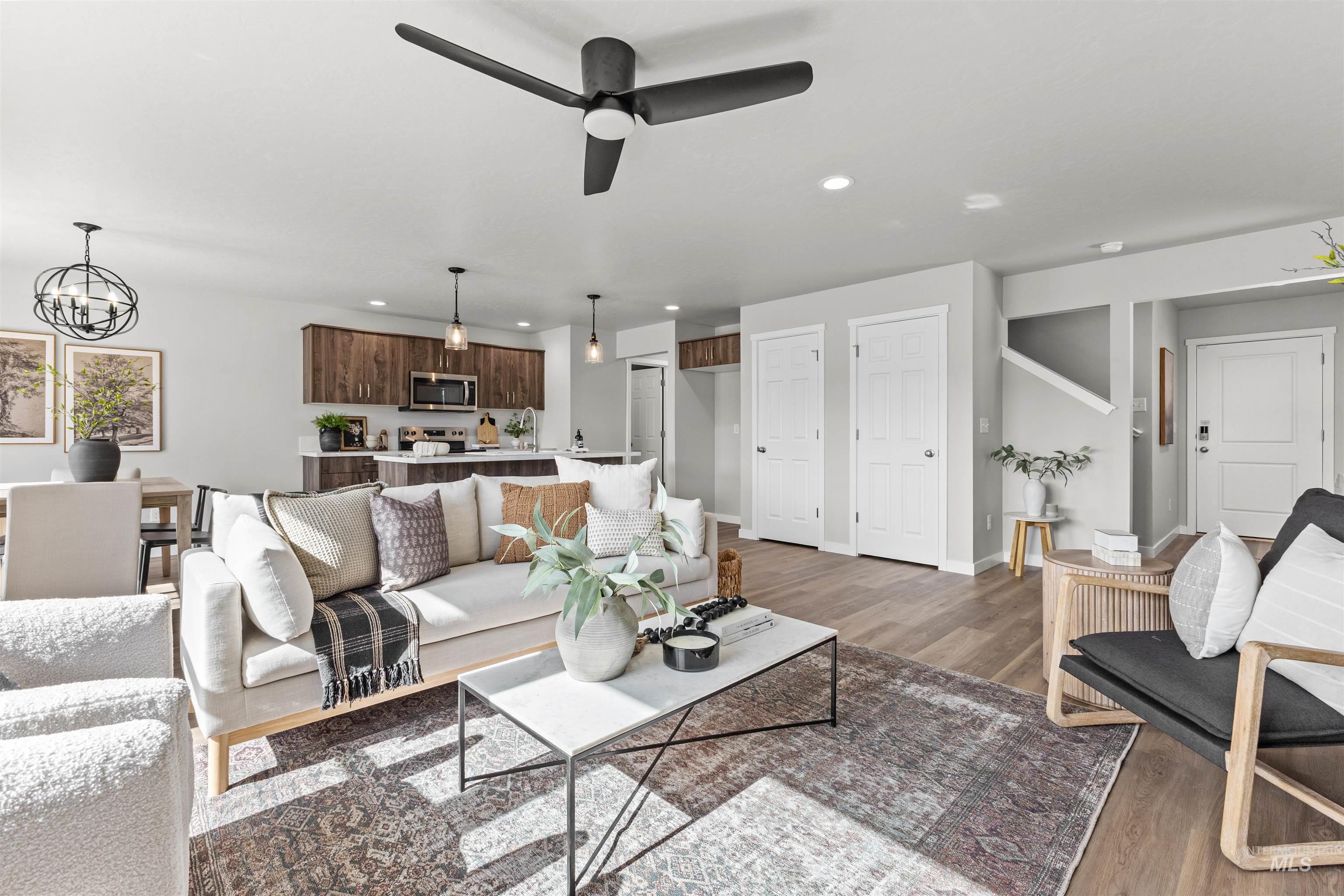 2534 West Fallon Loop Nampa, ID 83651 - Photo 10 of 28 Living room with dark wood-style flooring, ceiling fan, and a chandelier