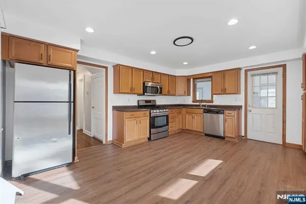 a kitchen with granite countertop stainless steel appliances refrigerator sink and cabinets