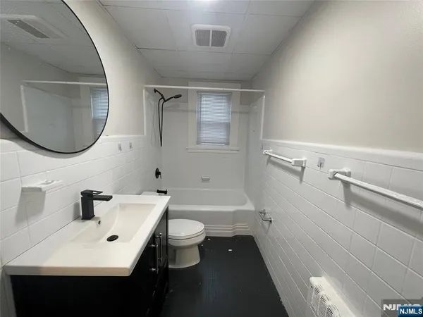 a bathroom with a sink a toilet and a mirror