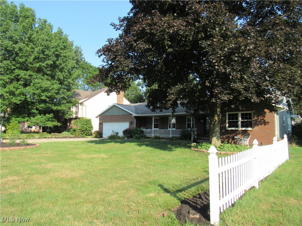 1120 Vincent Road Southeast North Canton, OH 44720 - Photo 3 of 50 View of right side of property featuring a garage, a front lawn, and covered porch