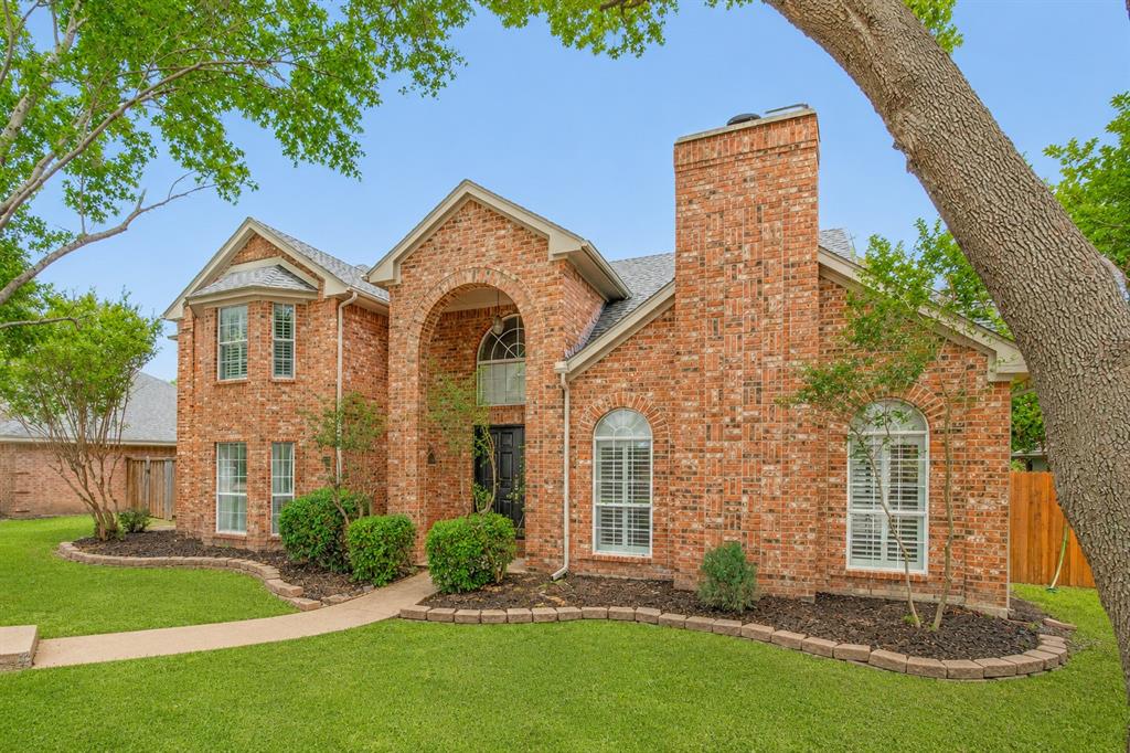 1215 Spring Creek Drive Allen, TX 75002 - Photo 2 of 40 Brick exterior featuring a prominent chimney, arched entryway, and bay window