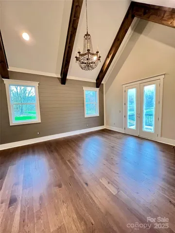 en empty room with wooden floor and windows