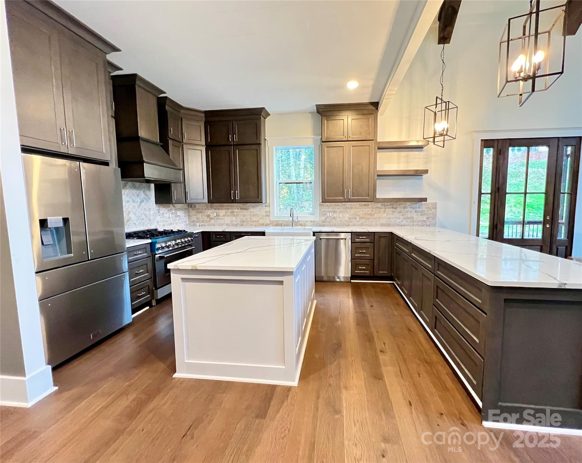 159 Comanche Road Cullowhee, NC 28723 - Photo 7 of 34 a kitchen with wooden floor and stainless steel appliances