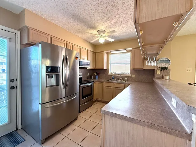 a kitchen with stainless steel appliances granite countertop a refrigerator a sink a stove and oven