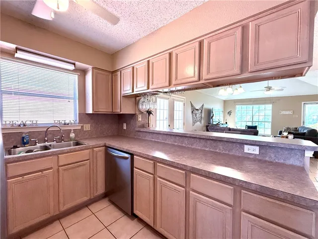 a kitchen with stainless steel appliances granite countertop a sink a stove cabinets and a window