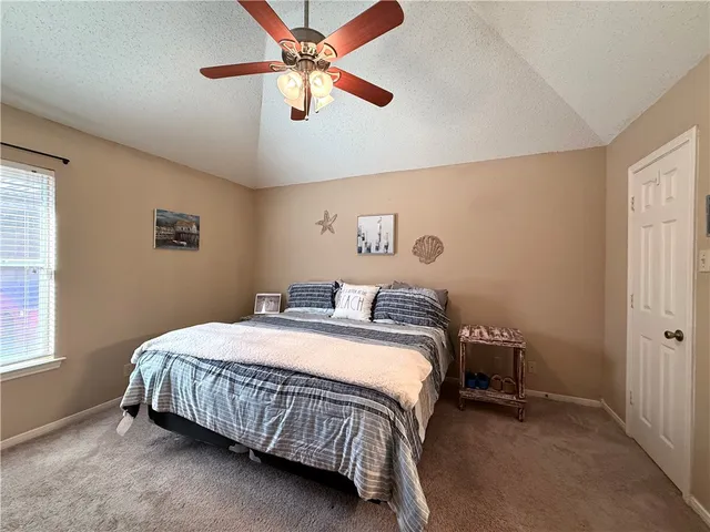 a bedroom with a bed chandelier and a window