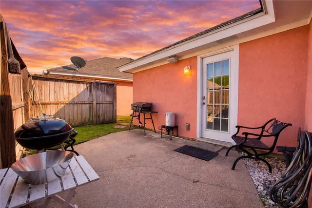 a view of a backyard with furniture and a grill