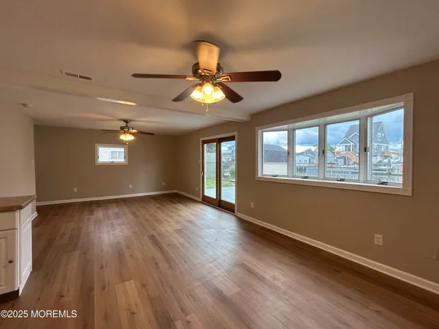 an empty room with a window and a fan