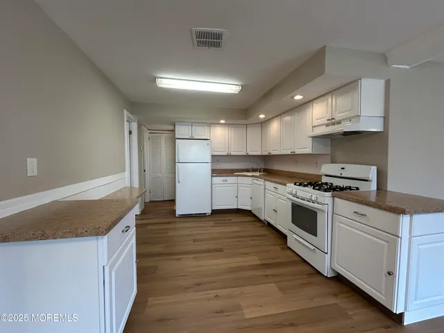 a view of a yard in front of a house with a large tree