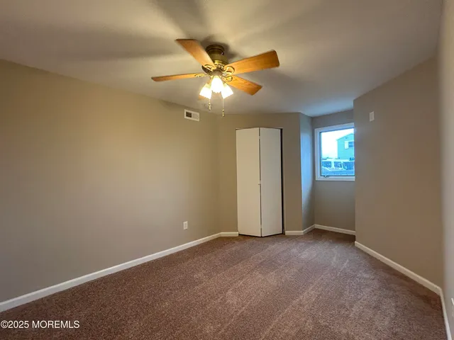 a view of a hallway with wooden floor and cabinet