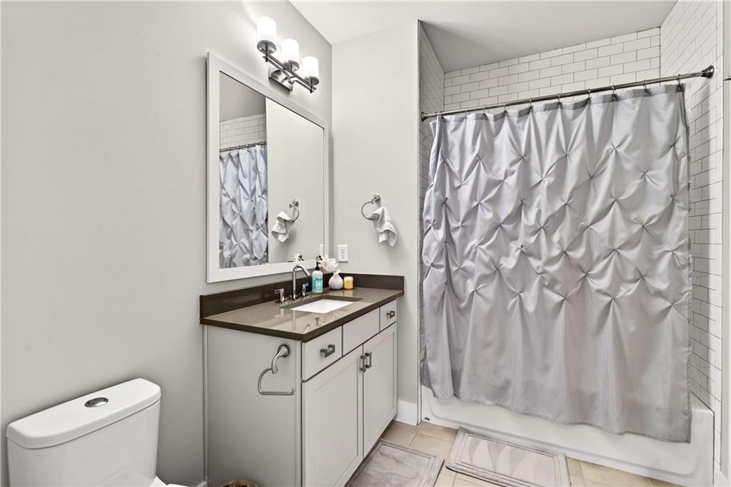 2974 Hermance Drive Northeast Atlanta, GA 30319 - Photo 20 of 38 a bathroom with a granite countertop sink a toilet and shower curtain