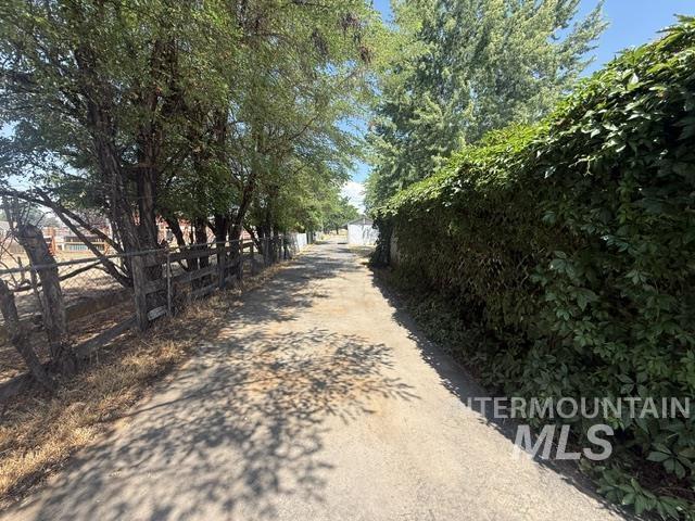 1360 Pioneer Road Weiser, ID 83672 - Photo 40 of 47 Paved pathway bordered by mature trees and a substantial green vine-covered wall