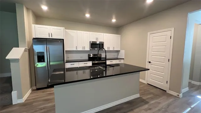 a kitchen with stainless steel appliances granite countertop a refrigerator and a stove top oven