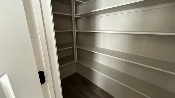 a view of walk in closet with empty racks