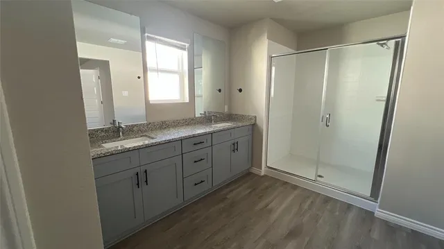 a bathroom with a granite countertop sink mirror and shower