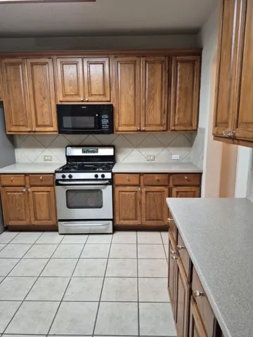 a kitchen with a stove top oven sink and cabinets