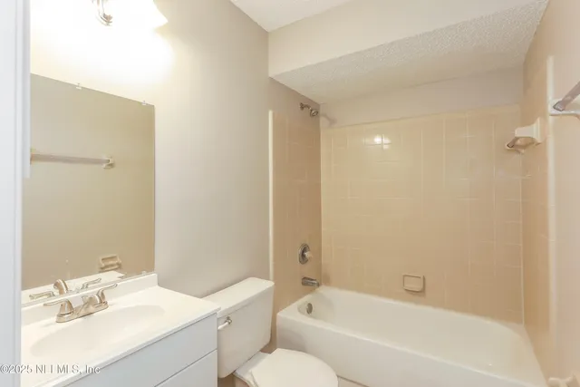 a bathroom with a bathtub shower sink vanity and toilet