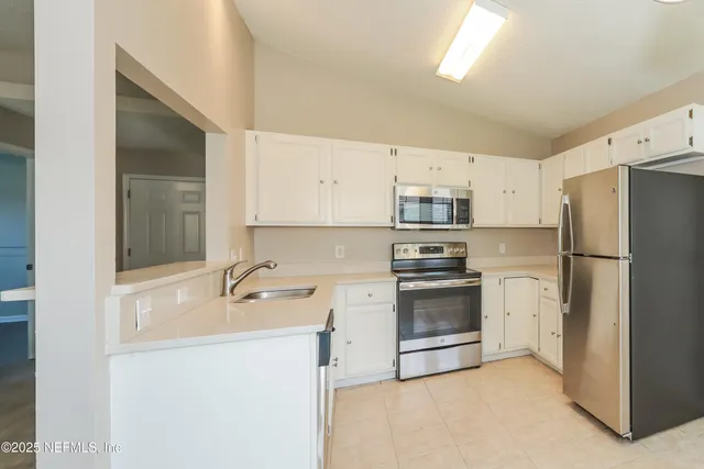 a kitchen with stainless steel appliances a refrigerator sink and stove