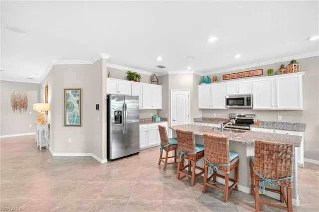 a kitchen with stainless steel appliances kitchen island granite countertop a refrigerator and microwave