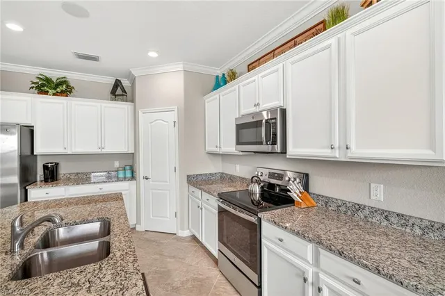 a kitchen with cabinets appliances a sink and a counter top space