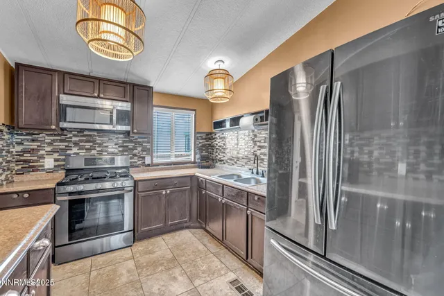 a kitchen with stainless steel appliances granite countertop a refrigerator and a stove