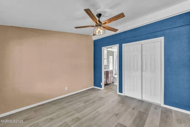 a view of a livingroom with a ceiling fan and wooden floor