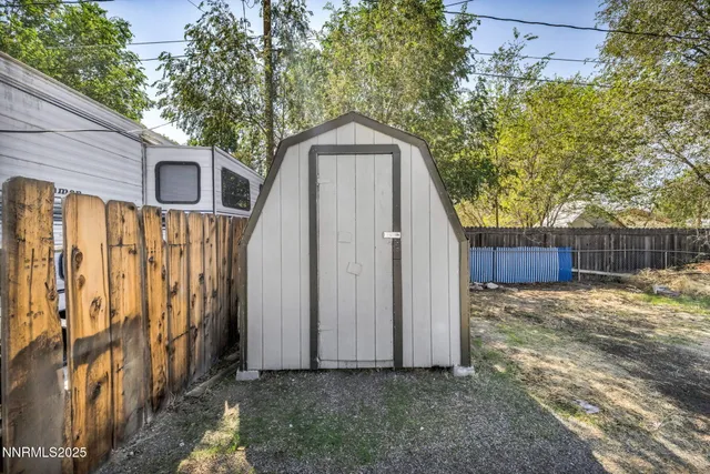 a backyard of a house with large trees and plants