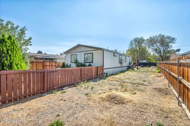 a view of a patio with table and chairs and wooden fence