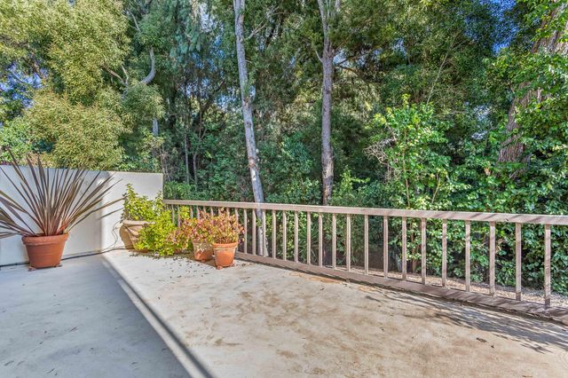 a balcony with chairs and wooden fence