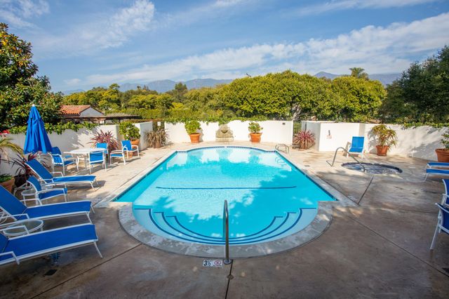 a view of a swimming pool with a chairs and tables in the patio
