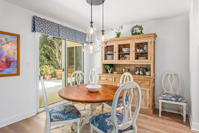 a dining room with furniture a chandelier and wooden floor