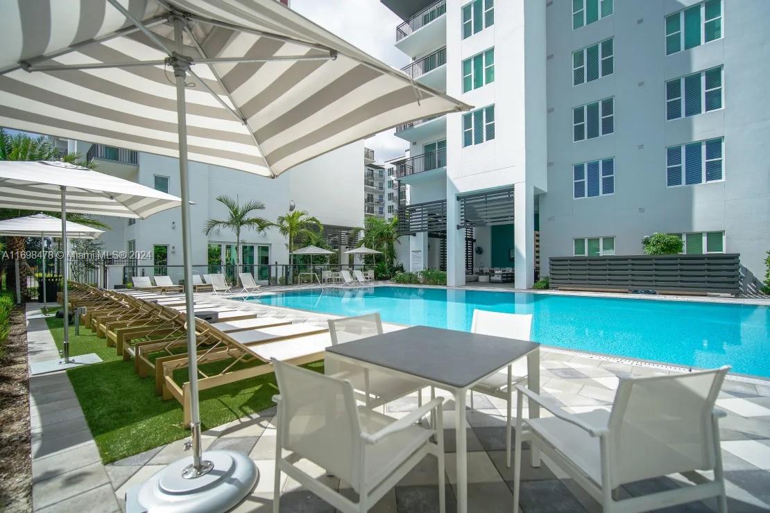 1919 Southeast 10th Avenue, Unit 5104 Fort Lauderdale, FL 33316 - Photo 10 of 35 a view of a patio with couches table and chairs under an umbrella