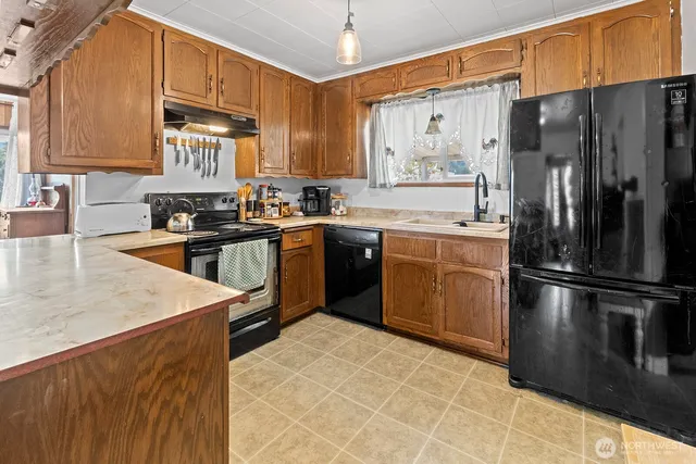 a kitchen with stainless steel appliances granite countertop a stove a sink and a microwave
