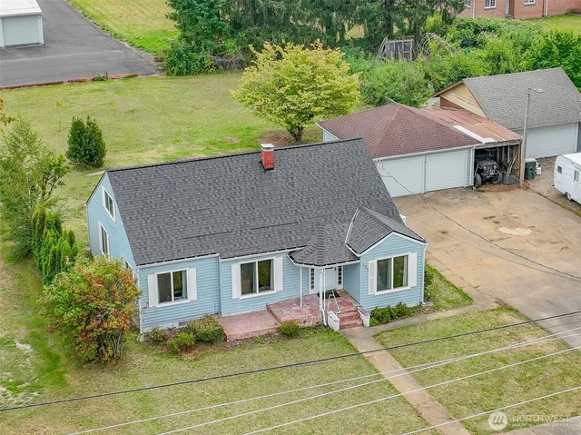 a aerial view of a house with table and chairs under an umbrella